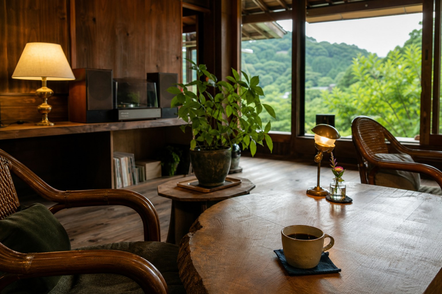 板張りの部屋に一枚板のテーブルと椅子が並び、卓上のランプが灯る喫茶室のイメージ